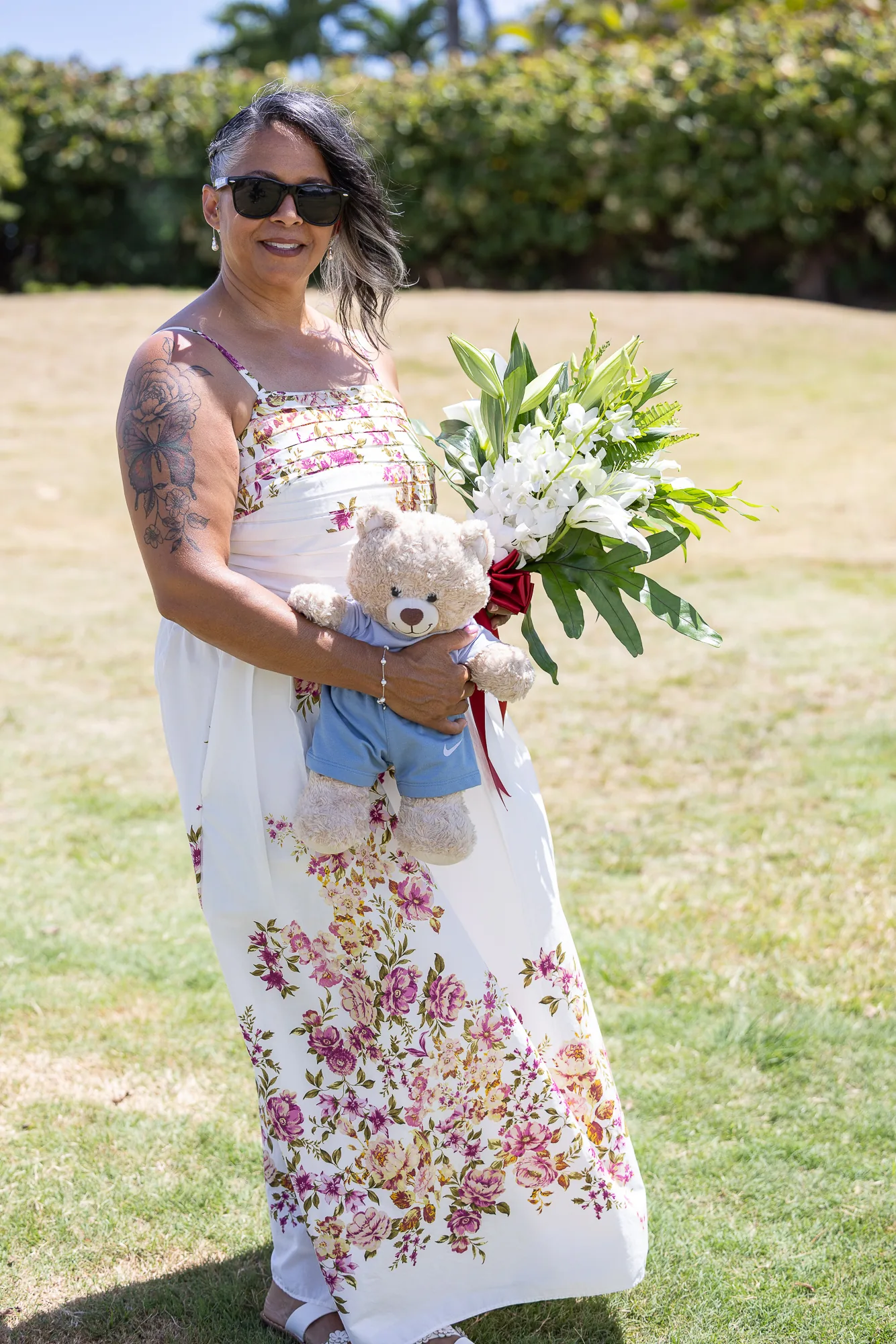 Jocelyn with her bouquet and a teddy bear on the grass
