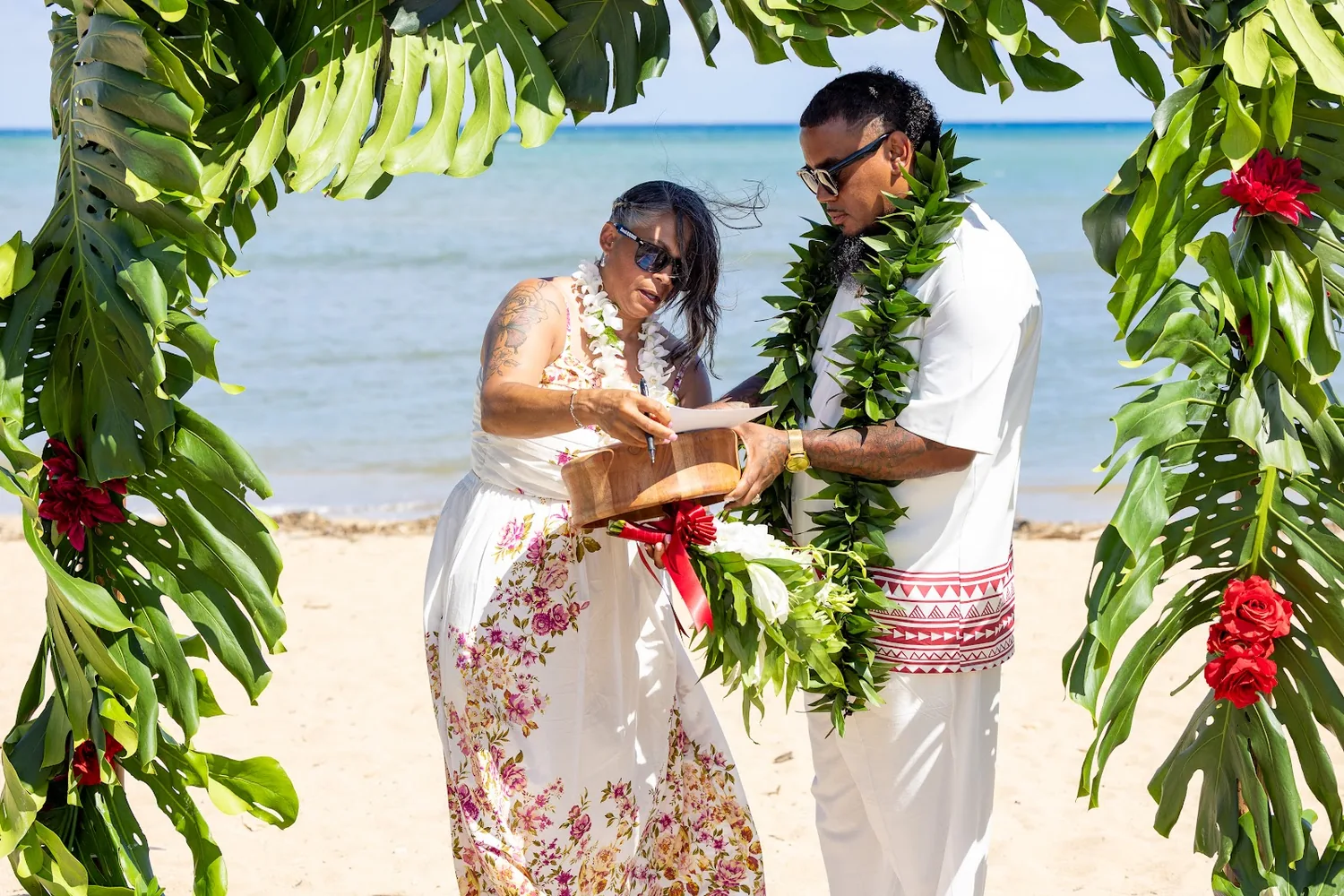 Jocelyn holding the kava bowl as Erick looks on under the arch