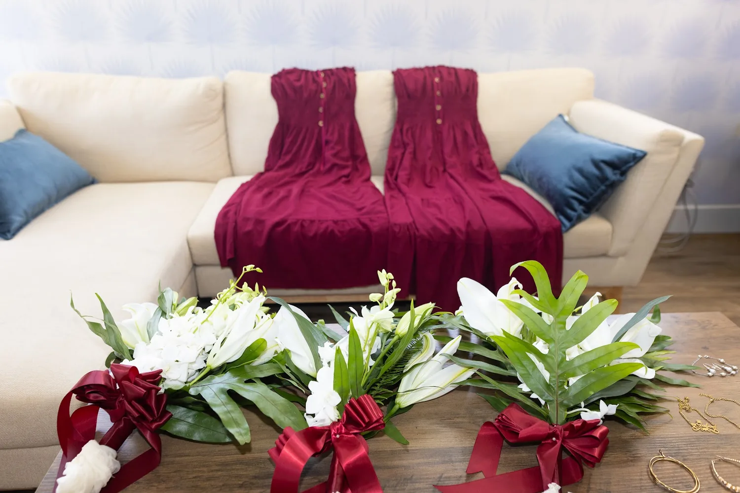 Wine red bridesmaid dresses on the sofa with the white bouquets