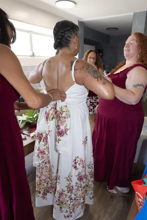 The bridesmaids helping Jocelyn into her dress