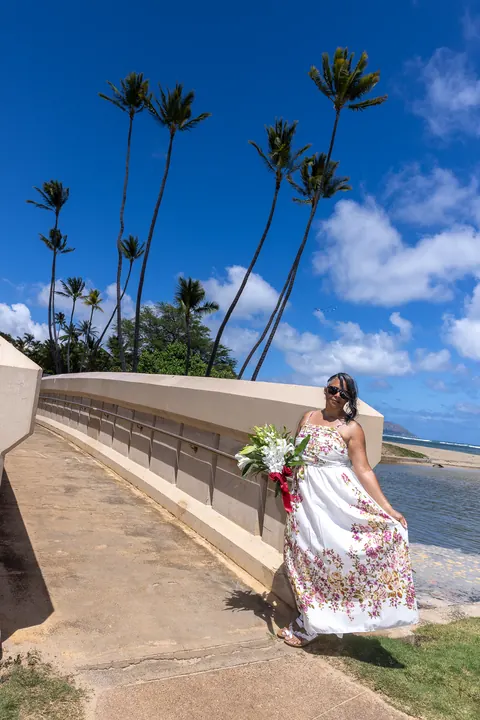 Jocelyn by the sea wall under tall palm trees