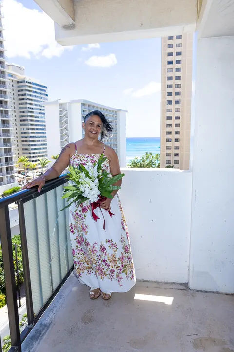 Jocelyn with her bouquet on a balcony above Waikiki