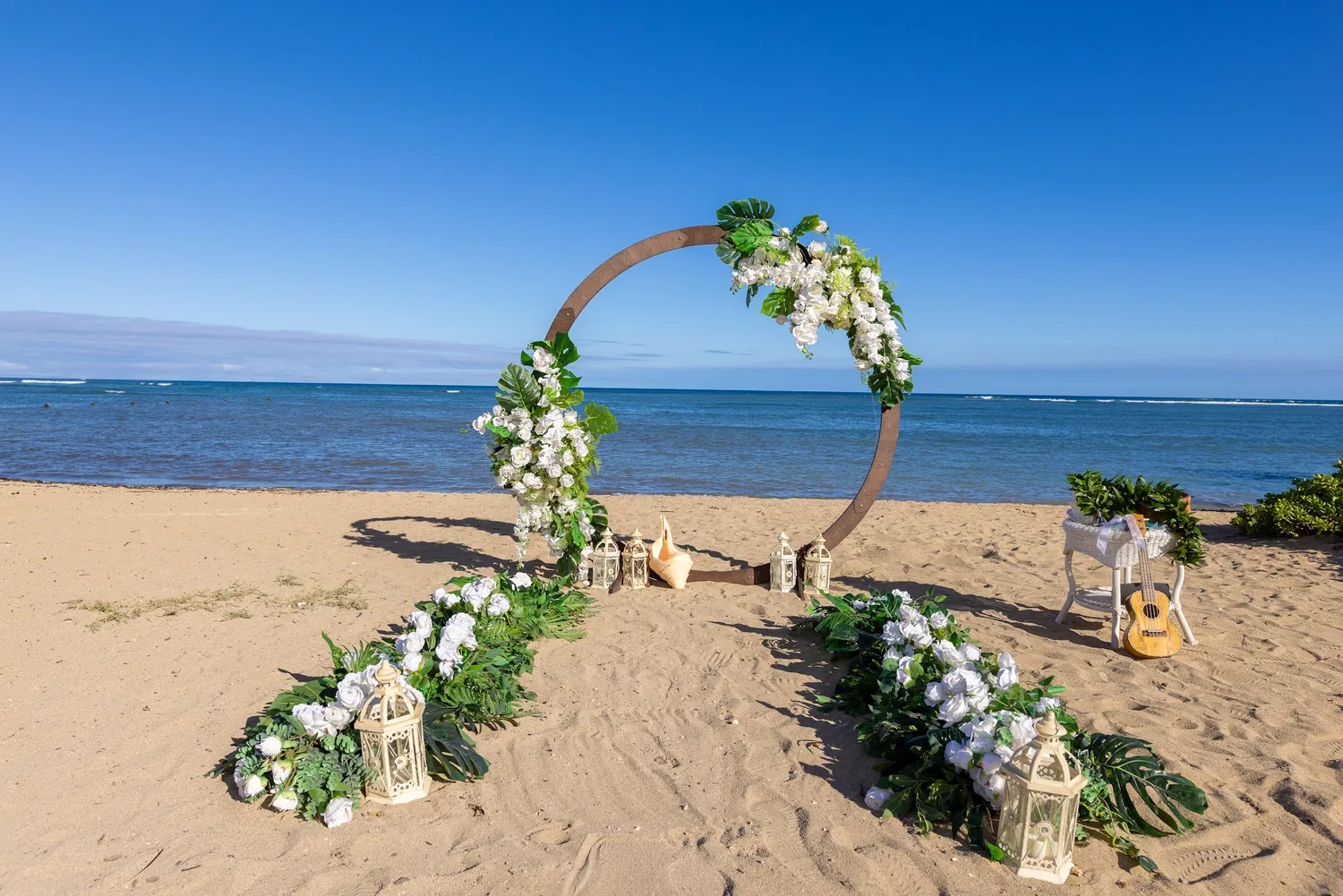 The circle archway facing the ocean with white flowers along the aisle