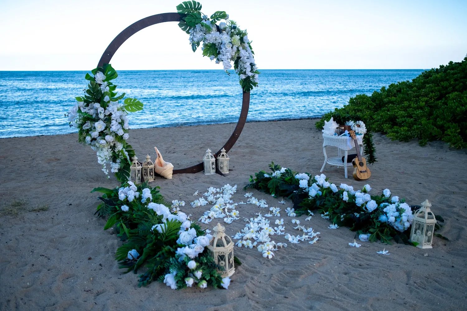 The circle archway with conch shells and white candle lanterns along the aisle