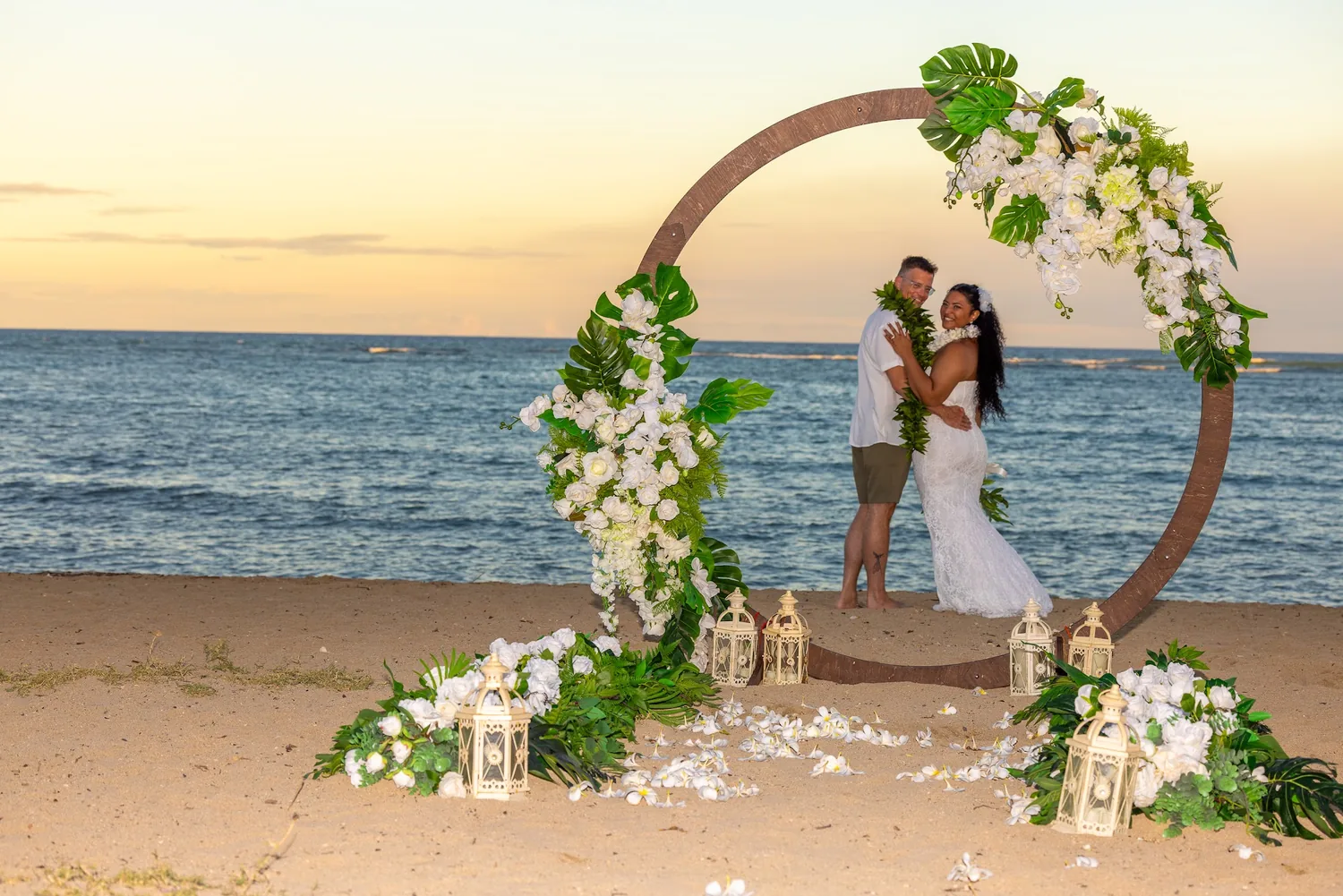 A golden sky behind the archway and the couple