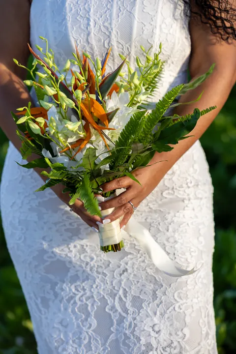 Close up of her bouquet of bird of paradise, white orchids and fern