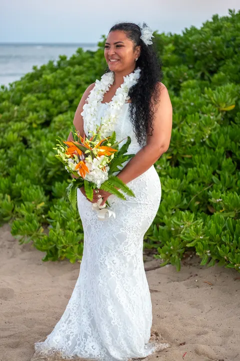 Dianna with her bouquet in front of the green naupaka bushes