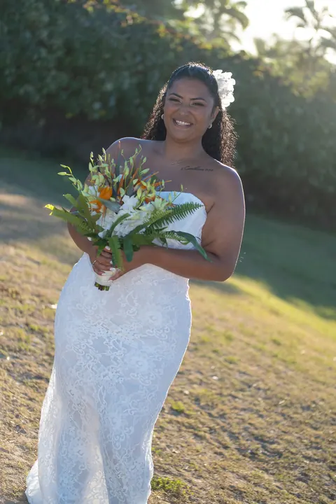 Dianna in her white lace gown on the grass in the late sun
