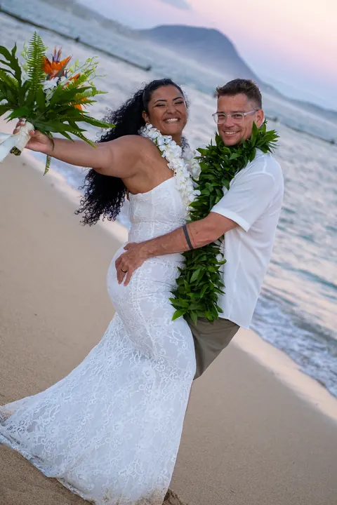 Dianna waving her bouquet on the shore with John