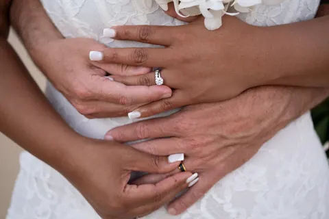 Their hands together showing their new wedding rings