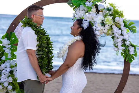Holding hands at the archway by the ocean