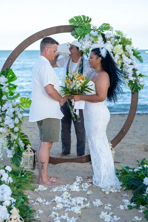 The officiant welcomes them at the circle archway