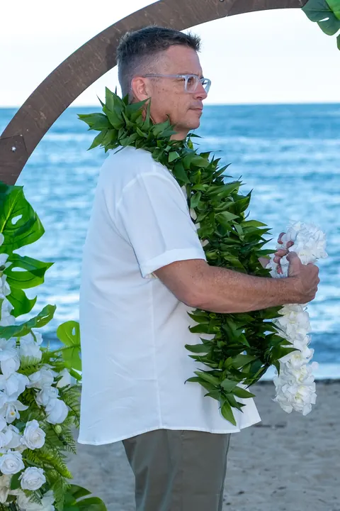 John in his maile lei holding Dianna&rsquo;s white orchid lei