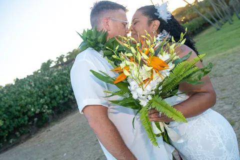 Hiding a kiss behind the bouquet on the lawn