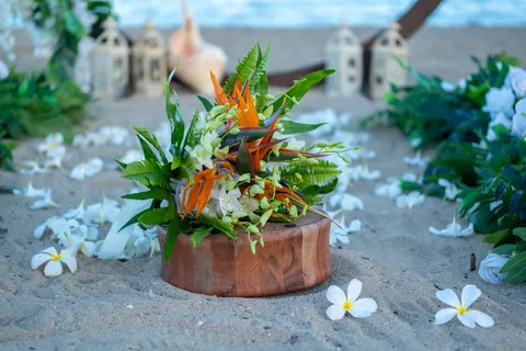 A tropical bouquet of white orchids, bird of paradise and green fern