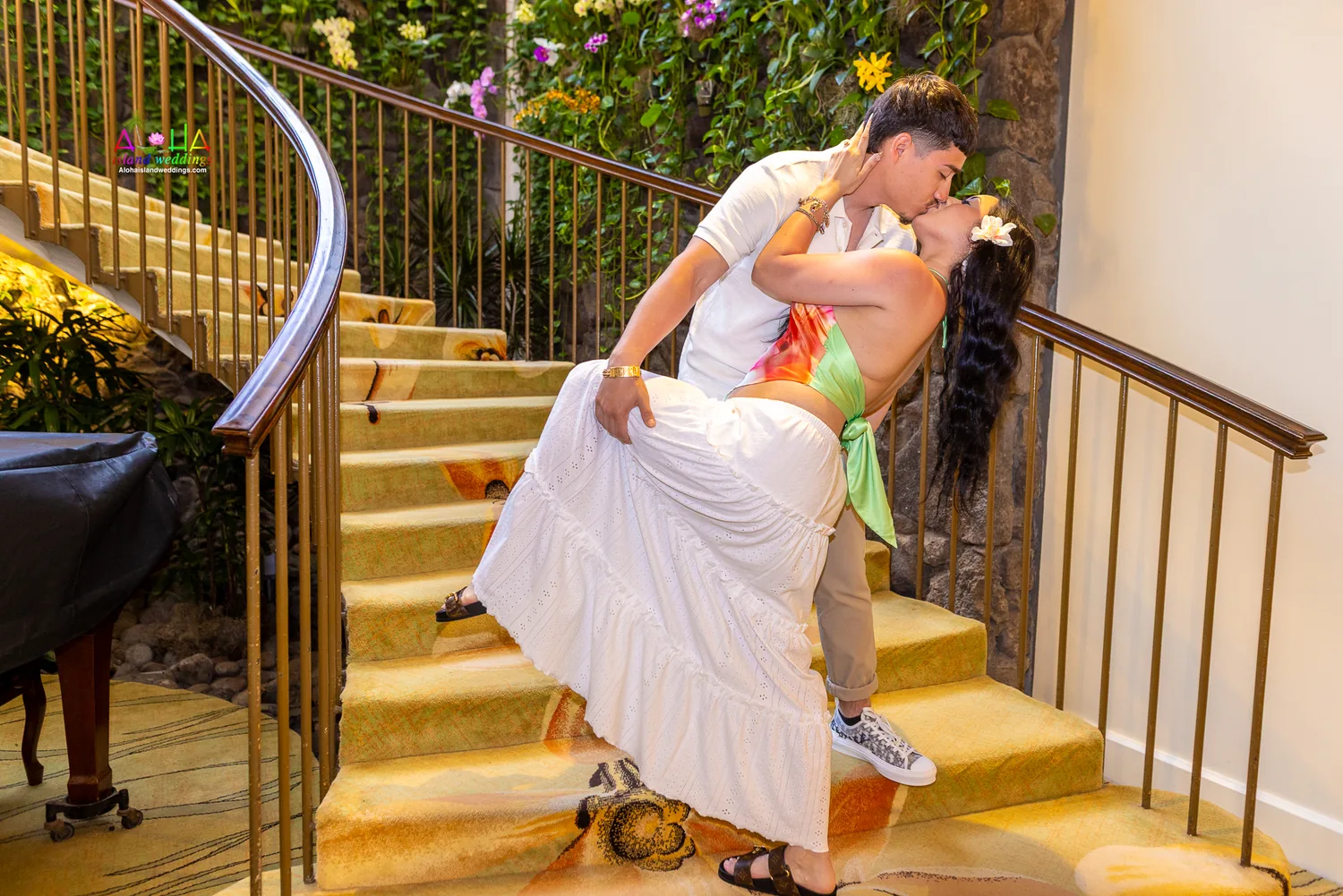 A dip kiss at the foot of the staircase