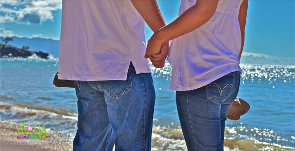 Holding hands before their wedding on Waimea beach Hawaii
