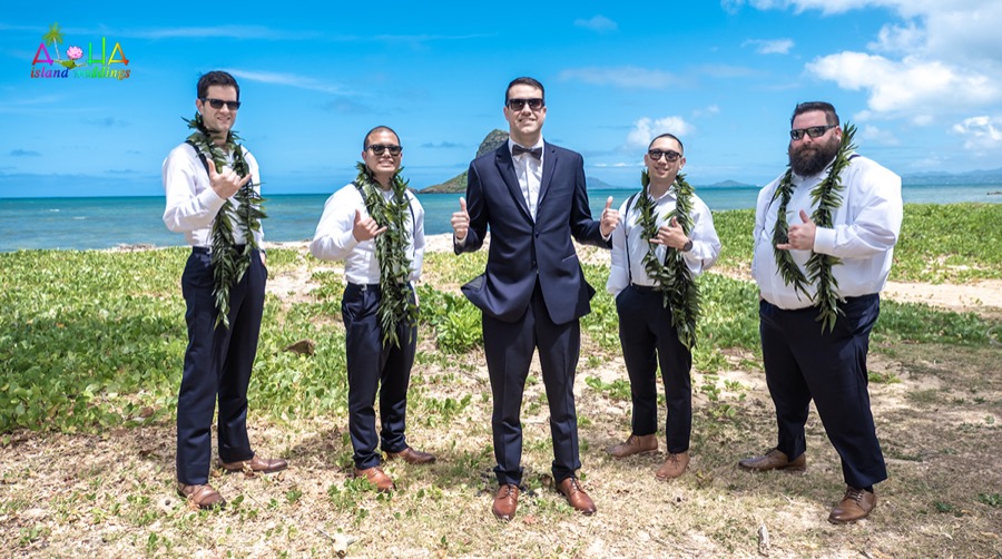 Groom and groomsmen in maile leis giving shakas with Chinaman's Hat behind them