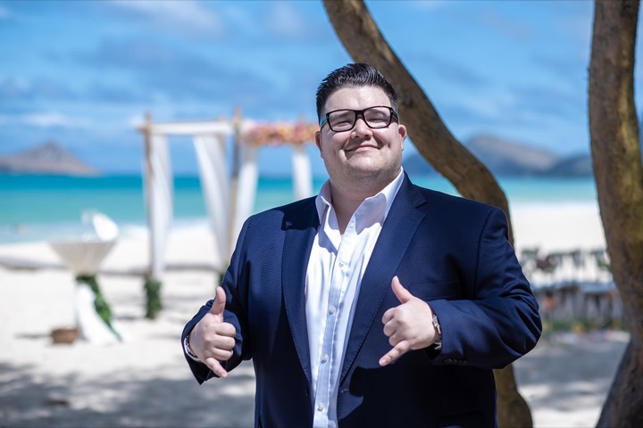 Johnathan smiling and giving the Hawaiian shaka sign