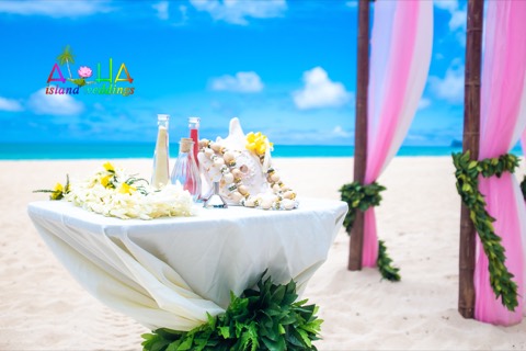 Flower leis on the table beside the sand ceremony at a Hawaii wedding