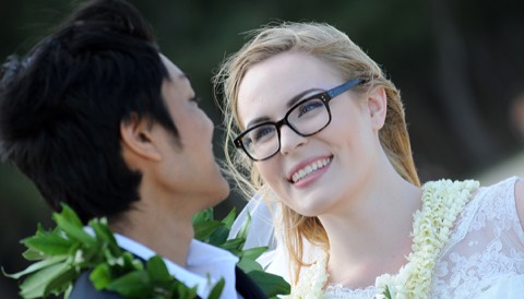 A couple in leis looking into each other's eyes after their beach ceremony in Hawaii