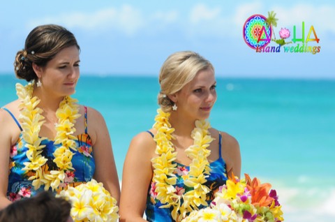 Bridesmaids wearing yellow plumeria leis by the ocean in Hawaii