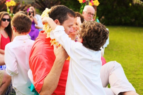 Giving a yellow plumeria lei before the ceremony at a Hawaii estate wedding
