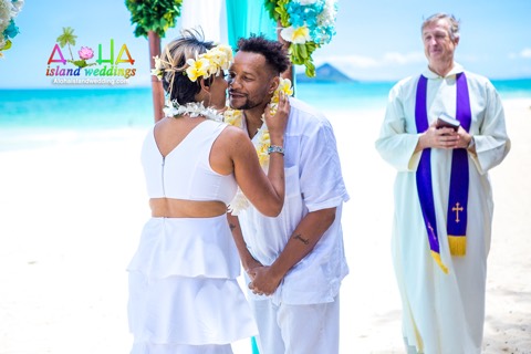 Adrienne and Cedric share a smile after their lei exchange on the beach in Hawaii