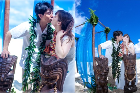 Toshi and Suzanne kiss beside a carved tiki in their flower leis at Waimanalo