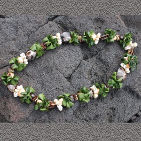 A kukui nut lei with ti leaf for the father of the bride on Oahu