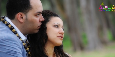 Close-up of the groom in a green maile lei with his bride at an Oahu wedding