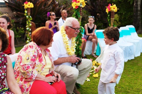 The ring boy gives grandma a yellow plumeria lei at an Oahu wedding