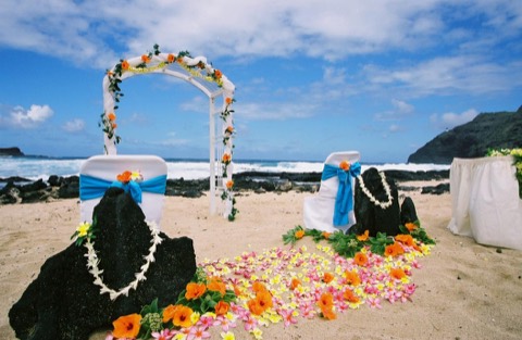 A white tuberose lei around a lava rock at a Hawaii beach wedding