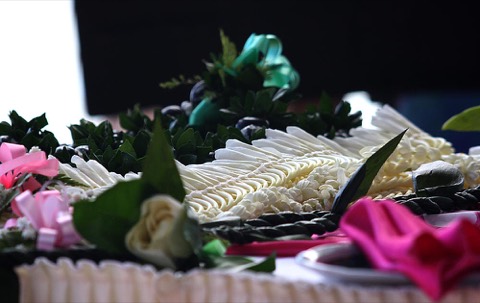 Kukui nut, orchid and ti leaf leis on the table at a beach wedding on Oahu