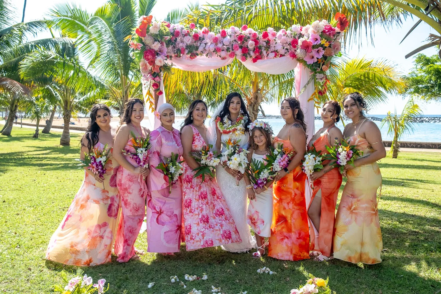 Bridesmaids in pink, orange and yellow with their bouquets