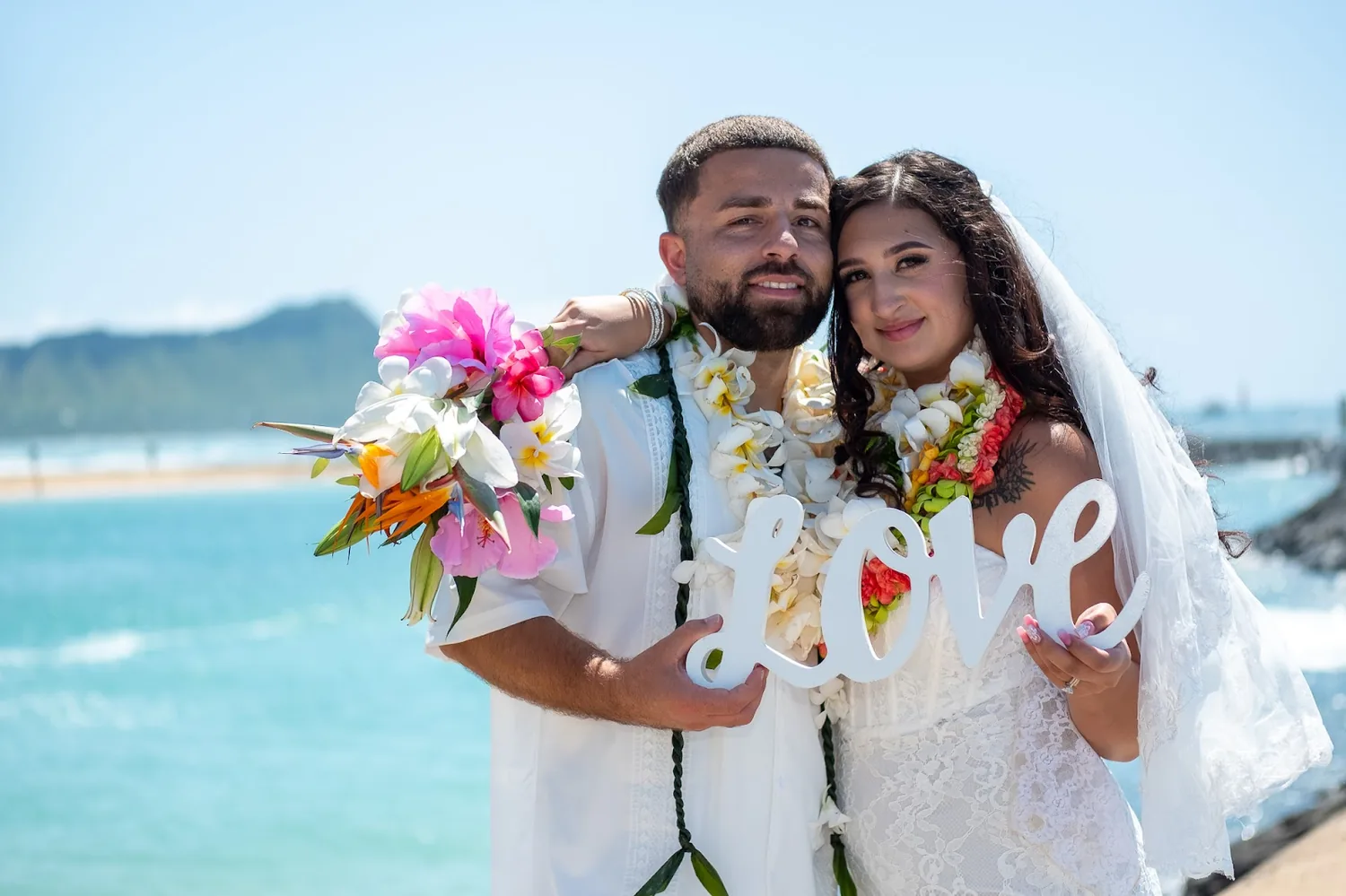 Lila and Mustafa with the LOVE sign and bouquet