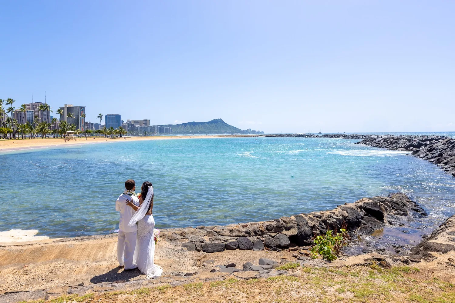Standing by the water with the Waikiki skyline