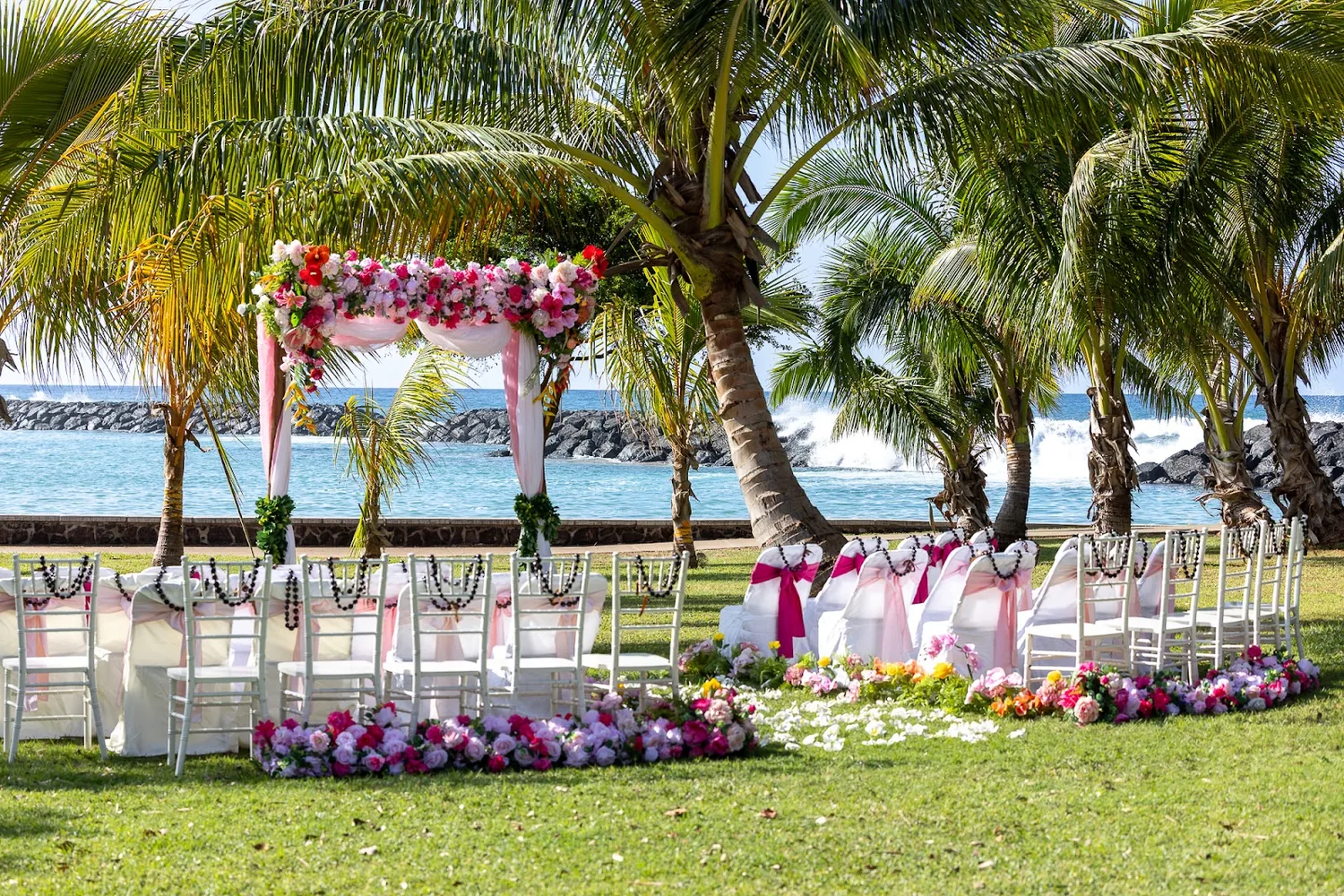 Wide view of the pink and cream ceremony setup by the water
