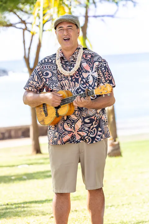 A ukulele player in an aloha shirt