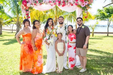 Bridesmaids in orange and pink with the couple