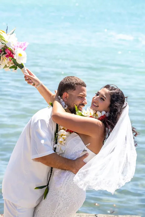 Lila holding her bouquet up as Mustafa smiles