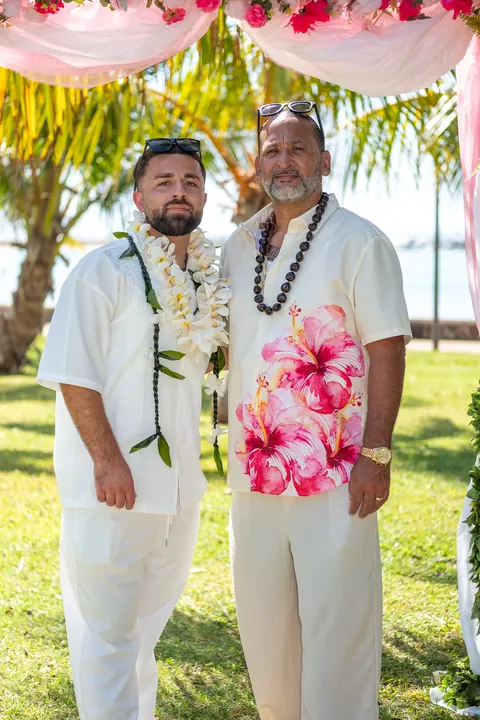 Mustafa with a family member in a pink lei