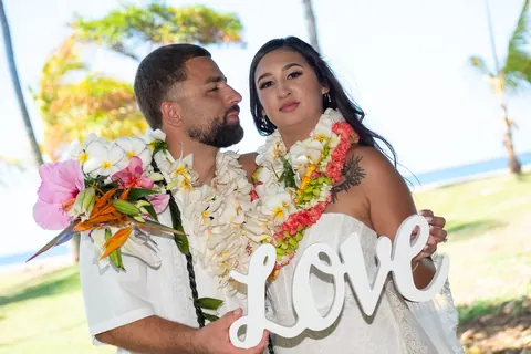 Smiling with the LOVE sign under the palms