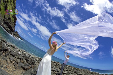 White chiffon from the wedding arch blowing in the wind at Makapuu