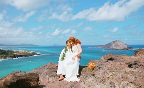 The couple framed by blue sky and sea
