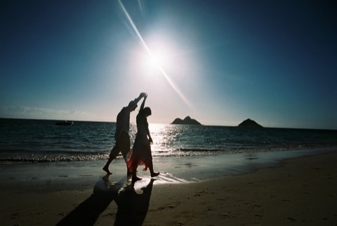 A couple dancing on the beach under the bright morning sun
