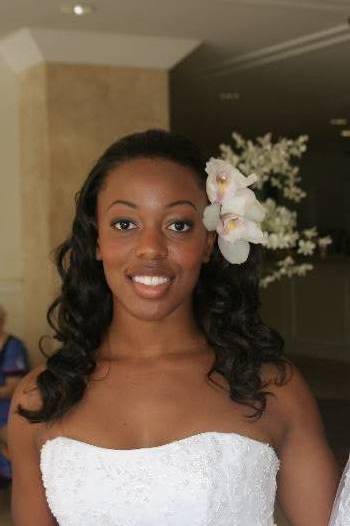 Naheshae getting ready with a white flower in her hair, in the sunshine
