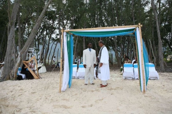 Guests seated on the sand under the ironwood trees