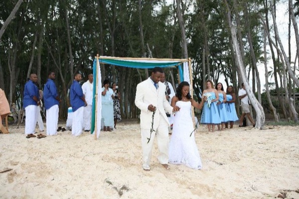 Guests seated on the sand under the ironwood trees, from another angle