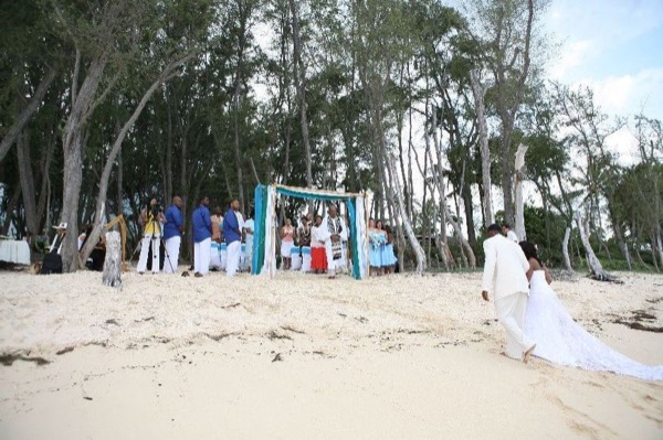 Guests seated on the sand under the ironwood trees, in the sunshine